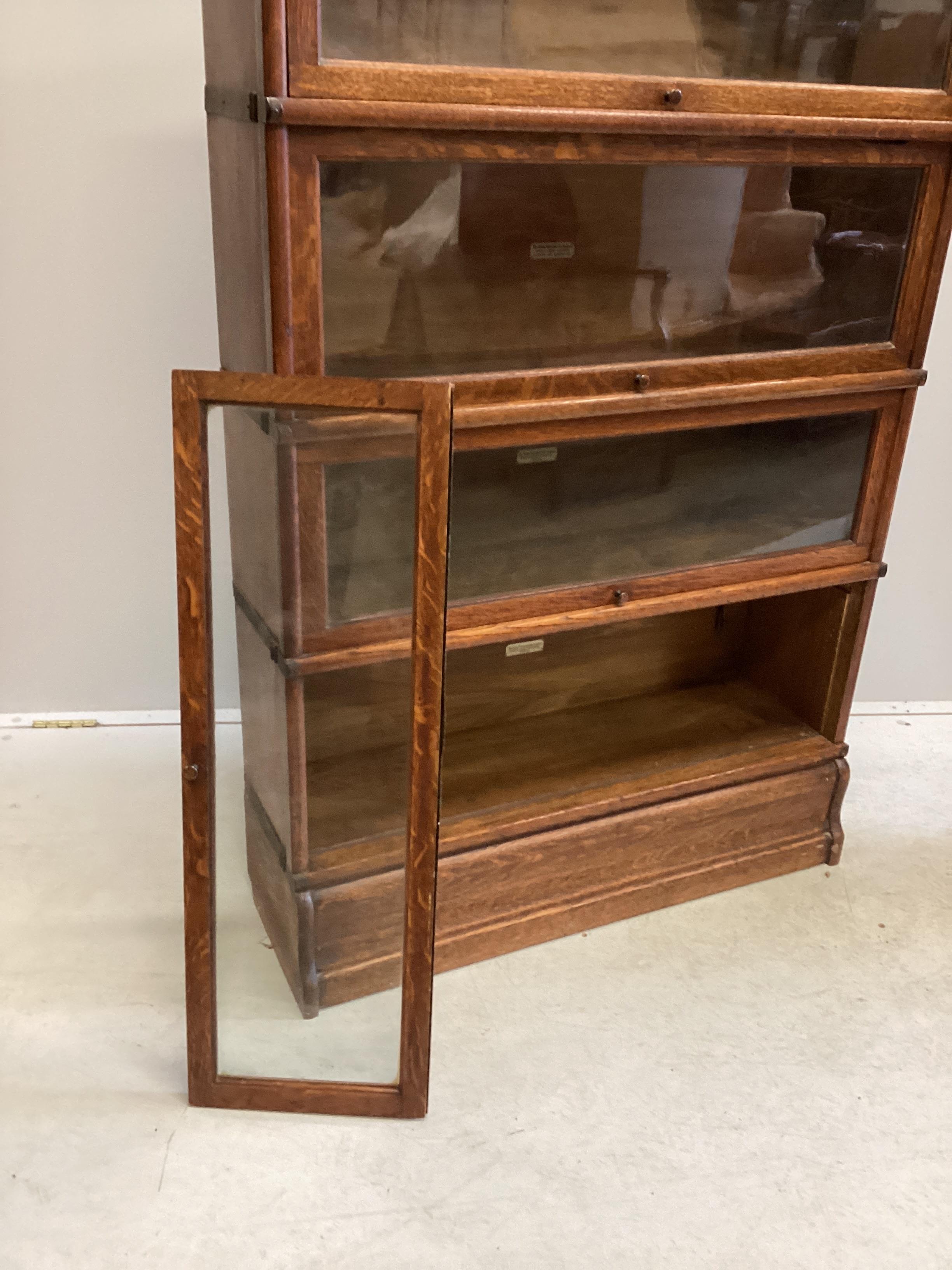 A Globe Wernicke oak four section bookcase, width 86cm, depth 27cm, height 140cm (one door detached)